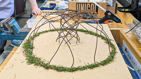 Desktop sized dome structure with fake grass sprinkled around