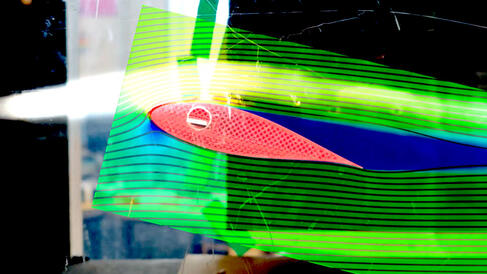 Air following over a wing in a wind tunnel with flow lines drawn on