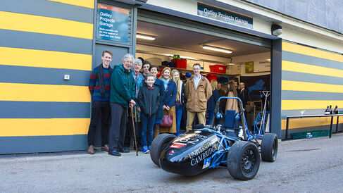 Grand opening of the Oatley Garage with people posing in front of the garage and a formula student car in the foreground
